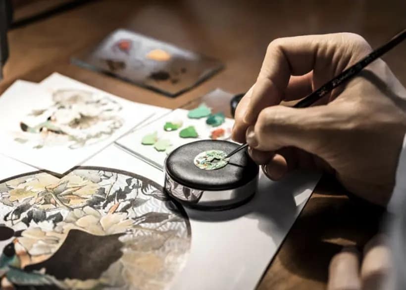 A close up of a craftman precisely assembling a decorative item
