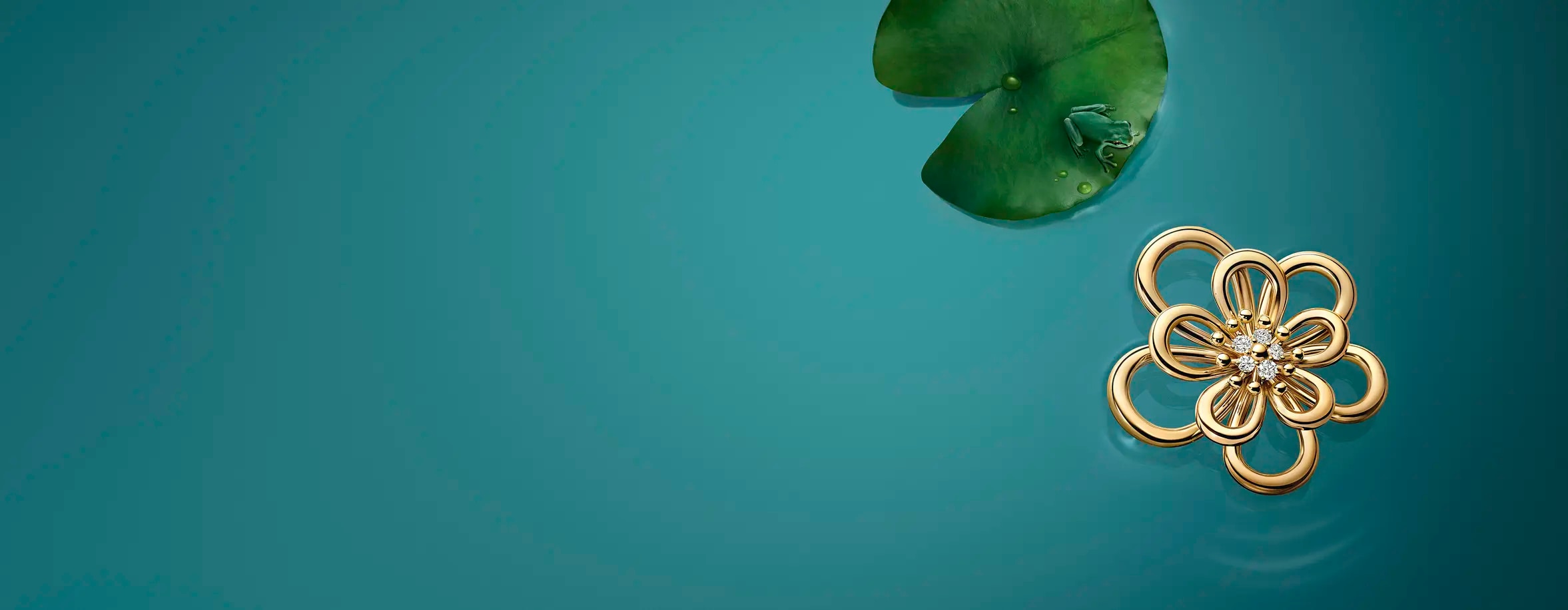 Image showcasing a delicate gold flower Van Cleef & Arpels pendant with diamond detailing, set against a serene blue backdrop with a lily pad and a tiny frog, evoking a sense of nature-inspired luxury.
